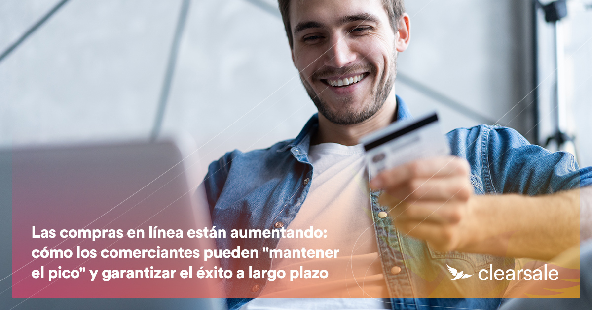hombre con su targeta de credito frente a su computadora